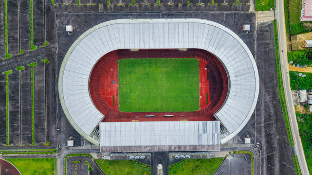 Aerial view of Godswill Akpabio Stadium with its distinctive oval shape, green pitch, red running track, and surrounding parking lots in Uyo, Akwa Ibom, Nigeria.