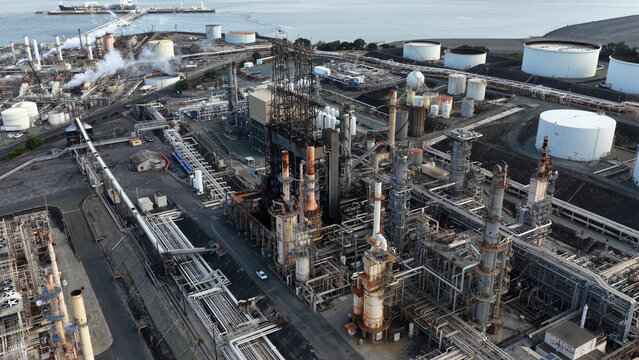 Aerial view of the Phillips 66 oil refinery featuring complex industrial piping, distillation towers, and large storage tanks near the waterfront in Rodeo, California, United States.