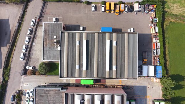 Aerial View of Industrial Park: An overhead drone shot captures a sprawling industrial park with various buildings, vehicles, and containers.