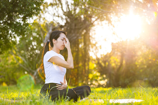 Woman practicing yoga breathing exercise in park