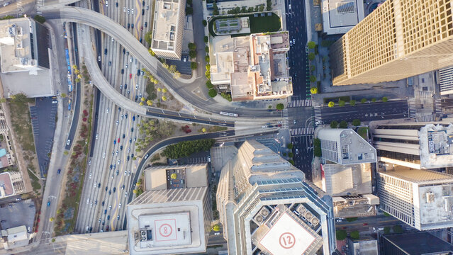 Aerial view of downtown Los Angeles skyline, featuring high-rise buildings, busy highway interchanges, and urban streets during the golden hour Los Angeles, California, United States.