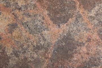 Closeup view of a natural grey and reddish-brown granite stone rock texture background. © Ink N Propeller