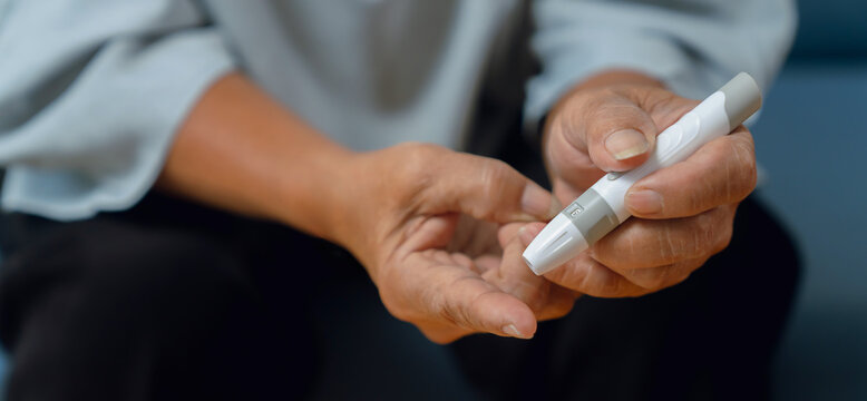 Elderly woman using a lancet for blood sugar testing at home, diabetes care and glucose monitoring.