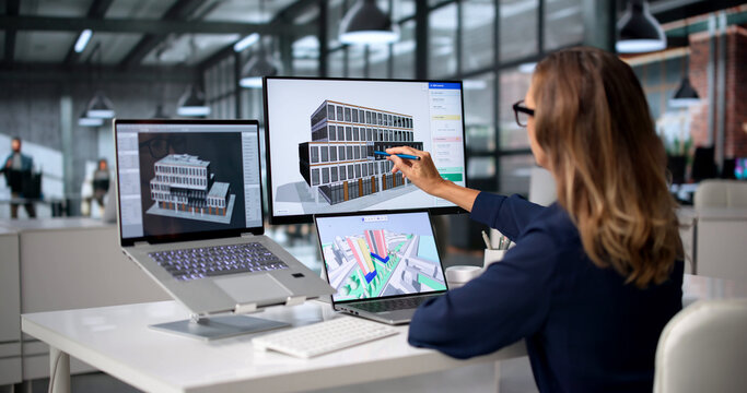 Architect Studies Detailed 3D BIM Model On Laptop