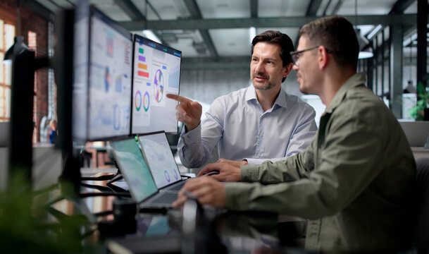 Financial Analysts Discuss Key Performance Data While Working