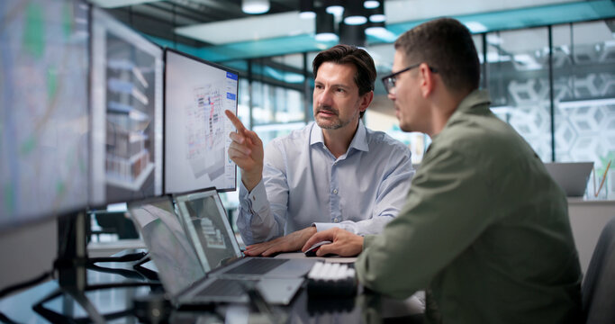 Architect Carefully Studies 3D Building Model On Laptop