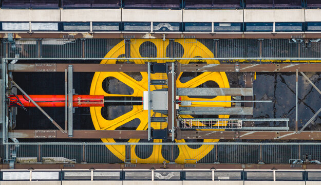 Aerial view of a large yellow cable car traction wheel and steel engineering structure in Seceda, Italy.