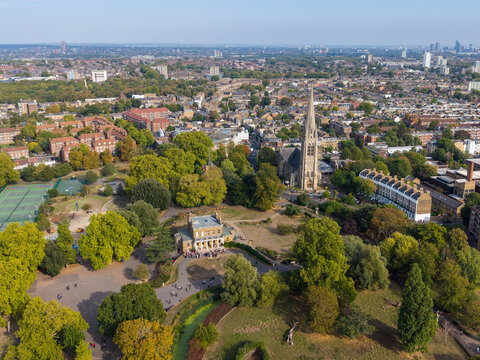 Aerial view of Stoke Newington featuring St Marys Church, lush green parkland, tennis courts, and residential streets in London, England, United Kingdom.