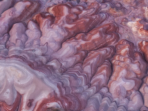 Aerial view of the Bentonite Hills showing colorful striped clay formations and undulating terrain in the desert landscape in Hanksville, Utah, United States.