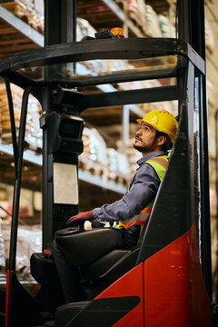 Forklift operator working in distribution warehouse.