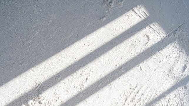 Minimalist white textured surface with diagonal sunlight shadows