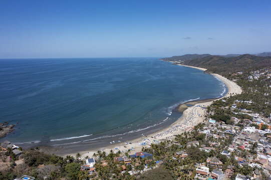 Aerial view of the coastal town of Sayulita with its sandy beach, turquoise ocean, and lush tropical vegetation in Sayulita, Nayarit, Mexico.