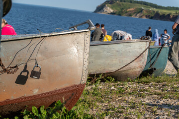 Vintage metal fishing boats parked on stony river shore © Dmitry