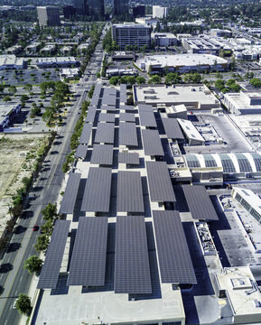 Aerial view of solar panel infrastructure installed on a large parking structure roof in an urban area in San Fernando, California, United States.