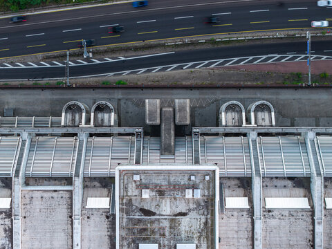 Aerial view of the ICC Berlin, a prominent example of Brutalist architecture with its distinctive geometric concrete roof, situated next to a busy highway in Berlin, Berlin, Germany.