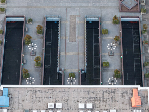 Aerial view of the brutalist architecture of the ICC Berlin, featuring geometric concrete structures, paved plazas, and symmetrical lighting fixtures in Berlin, Berlin, Germany.