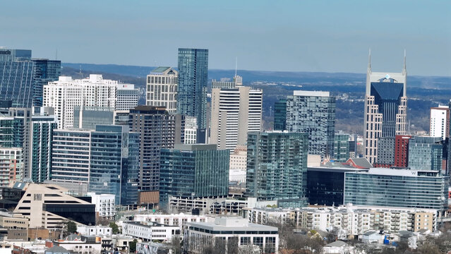 Aerial view of the Nashville skyline featuring modern skyscrapers, glass office buildings, and the iconic ATT Building under a clear blue sky in Nashville, Tennessee, United States.