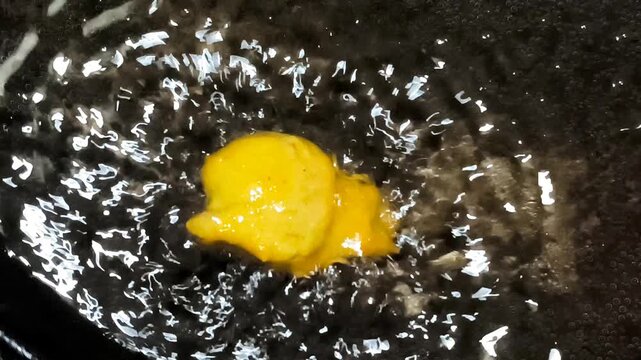 Macro Close Up of Single Pakora Fritter Sizzling in Boiling Hot Oil