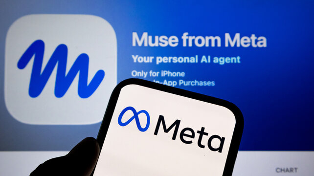 Smartphone displaying meta logo held against computer screen showing muse from meta app branding.