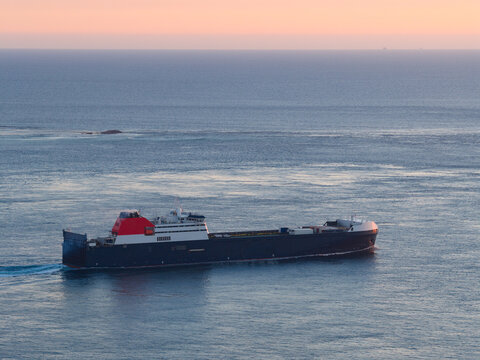 Aerial view of a cargo ship on the ocean in evening twilight