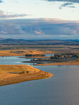 Aerial view of a colourful cloudbank over an inland lake with drive farmland around the shoreline