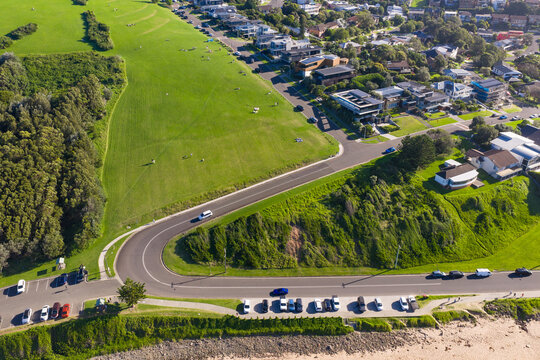 Aerial view of a winding road on a sloping green hillside