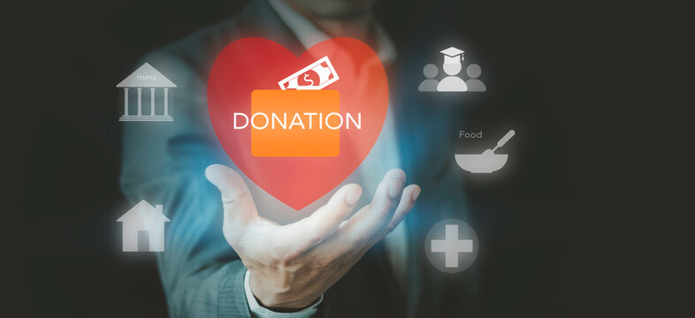 Businessman holding charity donation box and red heart concept. Philanthropy, corporate social responsibility CSR, education, healthcare, food relief, and housing support.