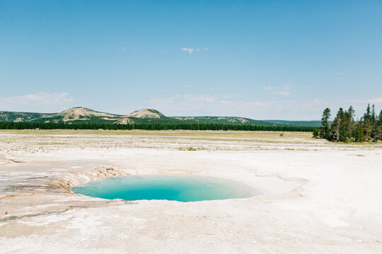 Turquoise blue hot spring in Yellowstone landscape
