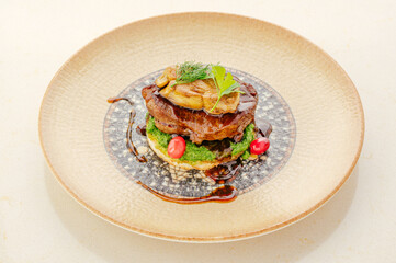 Beautifully plated gourmet steak with foie gras and greens © Cavan