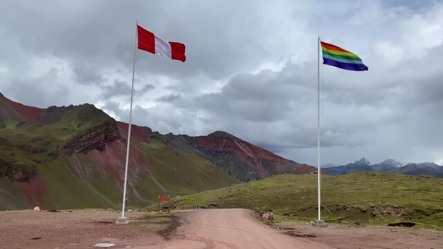 Peruvian and Pride flags wave over Rainbow Mountain in Peru