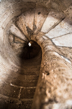 A dizzying view up an ancient stone spiral staircase