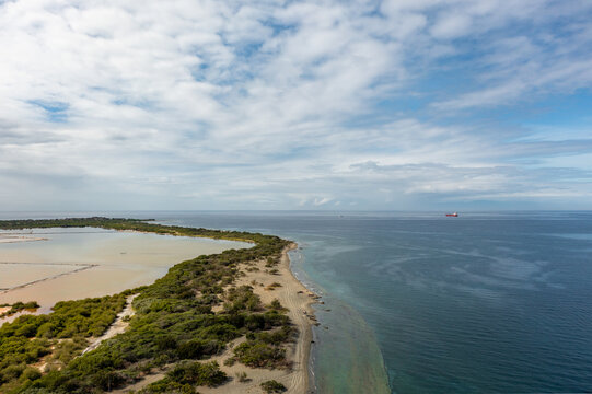 Aerial view of Playa Salinas de Bani featuring salt flats, coastal vegetation, and a sandy beach along the Caribbean Sea in Bani, Peravia, Dominican Republic.
