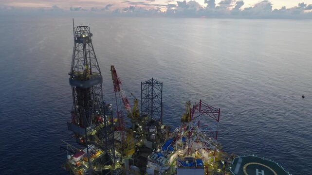Offshore drilling rig - jack up and offshore platform during sunset for oil and gas exploration and production. 