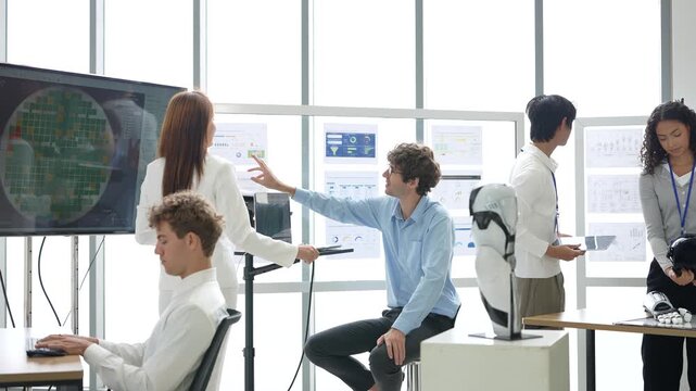 Woman in white suit points at a circular sensor scan screen while engineers work on laptops beside a humanoid robot, in a documentary-style moment, the future of human-robot collaboration