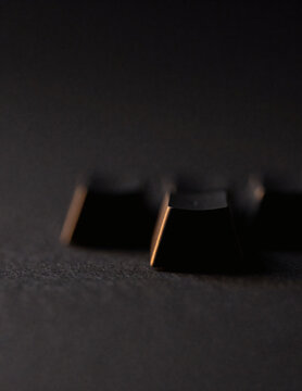 Close-up of a matte black keyboard keycap with warm highlight
