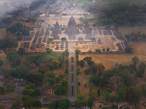 Aerial view of Prambanan Temple complex featuring ancient stone structures, symmetrical layout, and surrounding lush parkland in Kecamatan Prambanan, Daerah Istimewa Yogya, Indonesia.