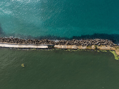 Aerial view of the Rio Ozama breakwater with concrete tetrapods separating the river from the Caribbean Sea in Santo Domingo, Santo Domingo, Dominican Republic.