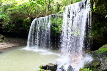 Nabegataki waterfall flowing over lush green cliff in Kumamoto Japan © Takuya Sato