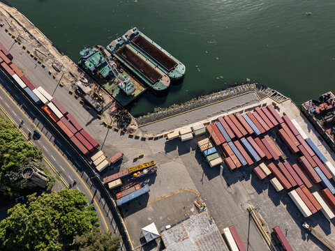 Aerial view of Rio Ozama with cargo barges, shipping containers, and port infrastructure in Santo Domingo, Santo Domingo, Dominican Republic.