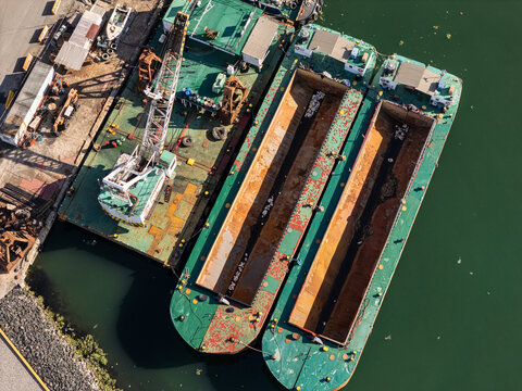 Aerial view of Rio Ozama with industrial barges and a crane moored along the riverbank in Santo Domingo, Santo Domingo, Dominican Republic.