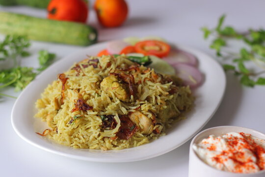 Chicken pulao with basmati rice, tender chicken, fried onions, fresh salad and yogurt side