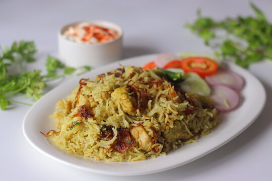 Chicken pulao with basmati rice, tender chicken, fried onions, fresh salad and yogurt side