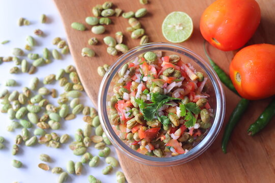 Roasted edamame bean salad with tomato, onion, carrot and fresh coriander in a glass bowl