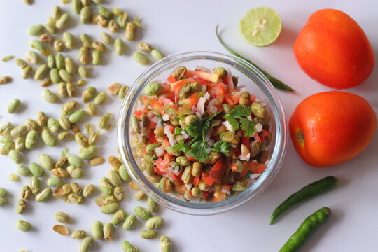 Roasted edamame bean salad with tomato, onion, carrot and fresh coriander in a glass bowl
