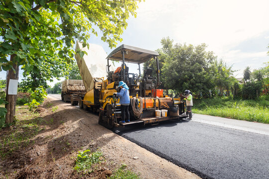Asphalt road roller with heavy vibration roller compactor press new hot asphalt on the roadway on a road construction site. Heavy Vibration roller at asphalt pavement working. Repairing.