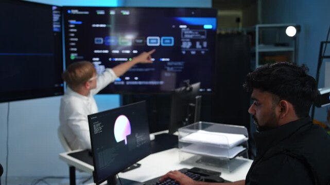 Engineers coding together in modern tech workspace