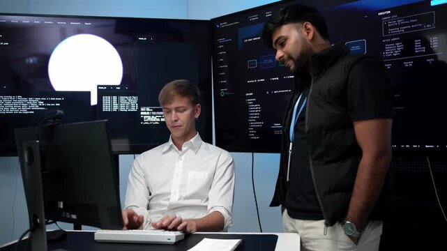 Two coders analyzing code on large screens