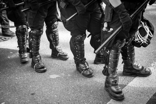 A line of police officers wearing full riot gear