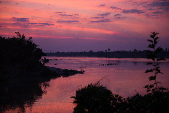 Vibrant pink sunset reflecting over a tranquil river