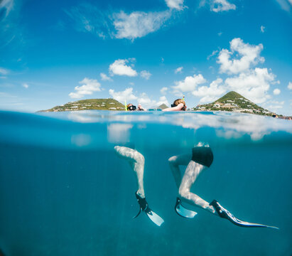 Over under split shot of snorkelers in the sea